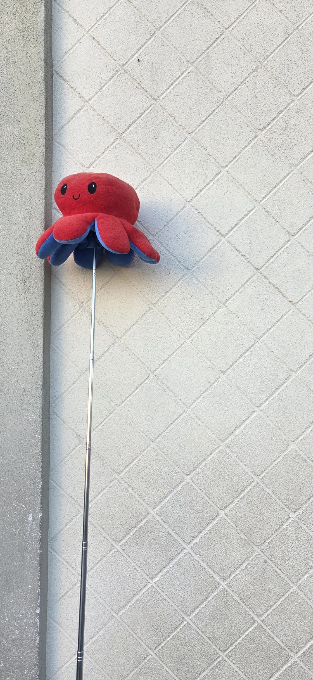 El palo de guía de Carles con su peluche de pulpo rojo, la seña de Comboi