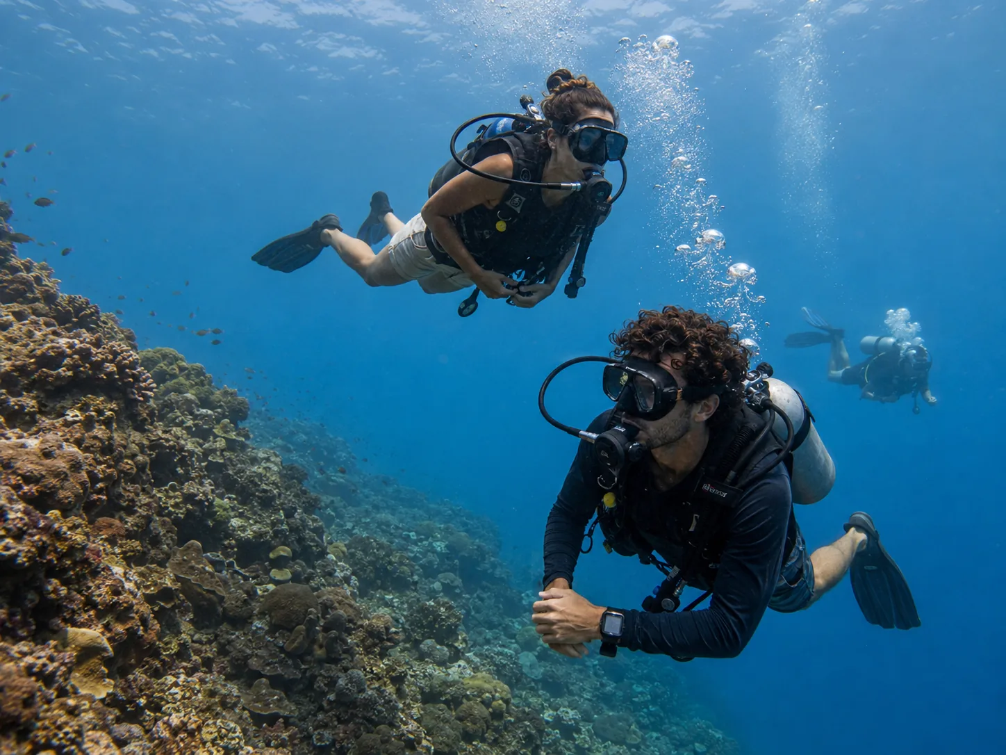 Dos viajeros de Comboi Travel buceando entre corales en un arrecife de Koh Tao, Tailandia